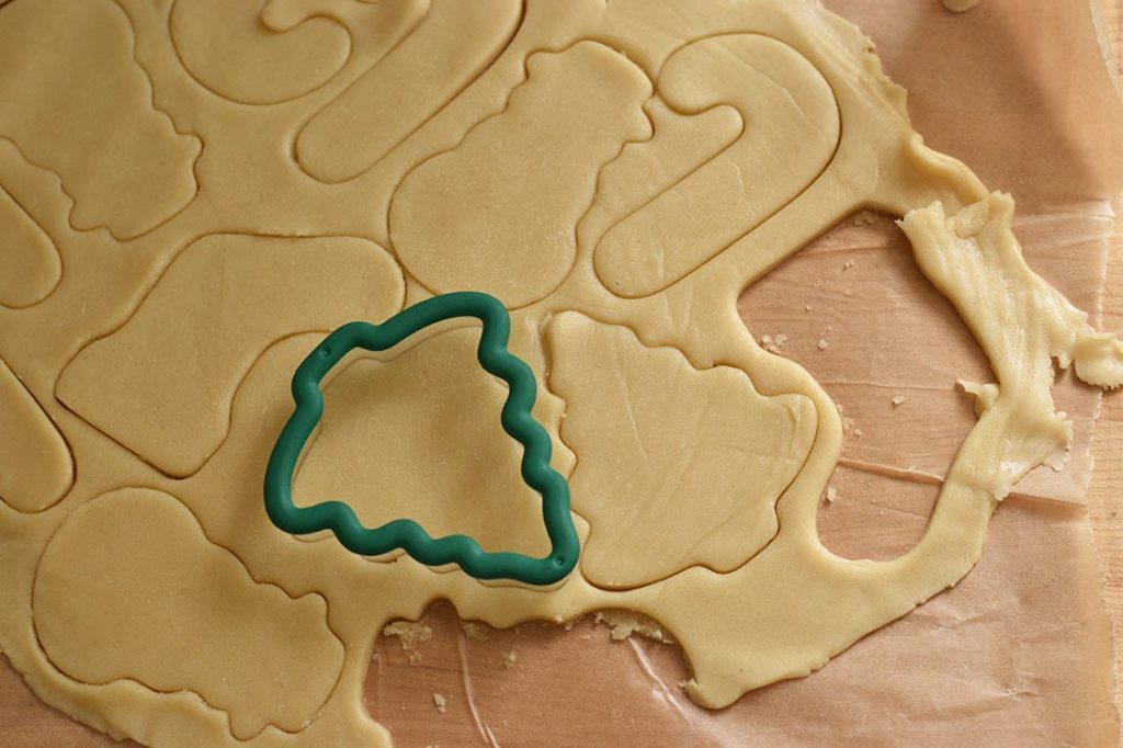 Xmas cookie dough being cut with a cookie cutter