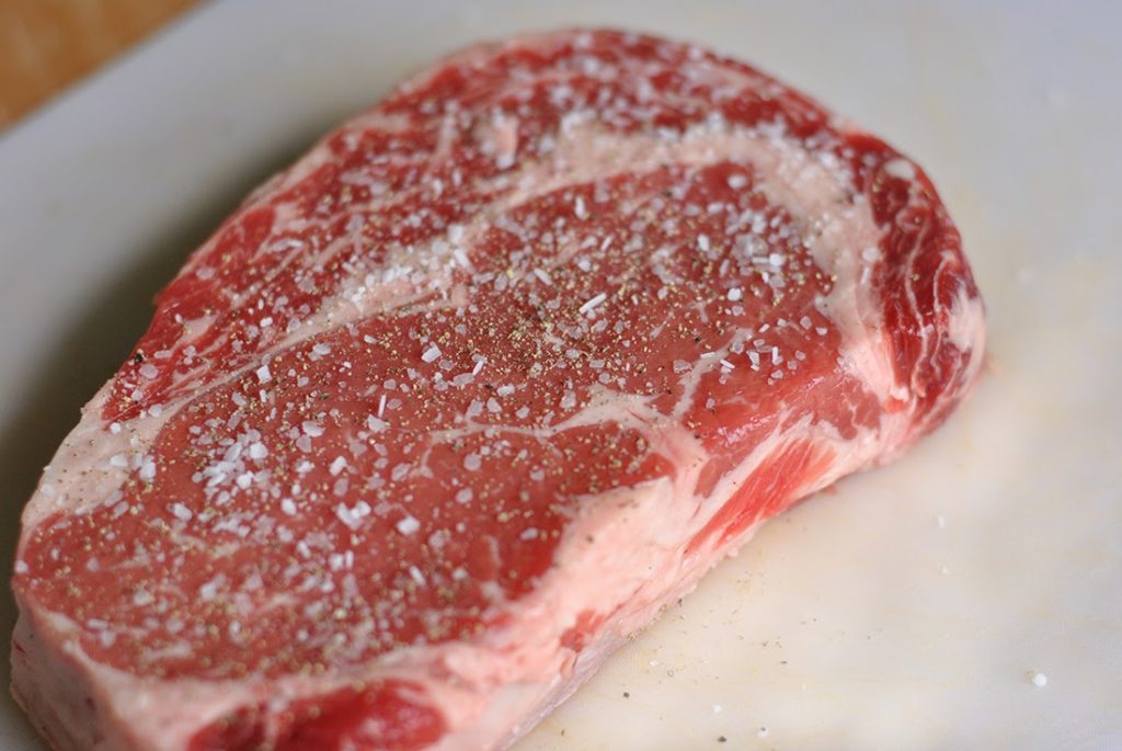 Seasoned raw steak with salt