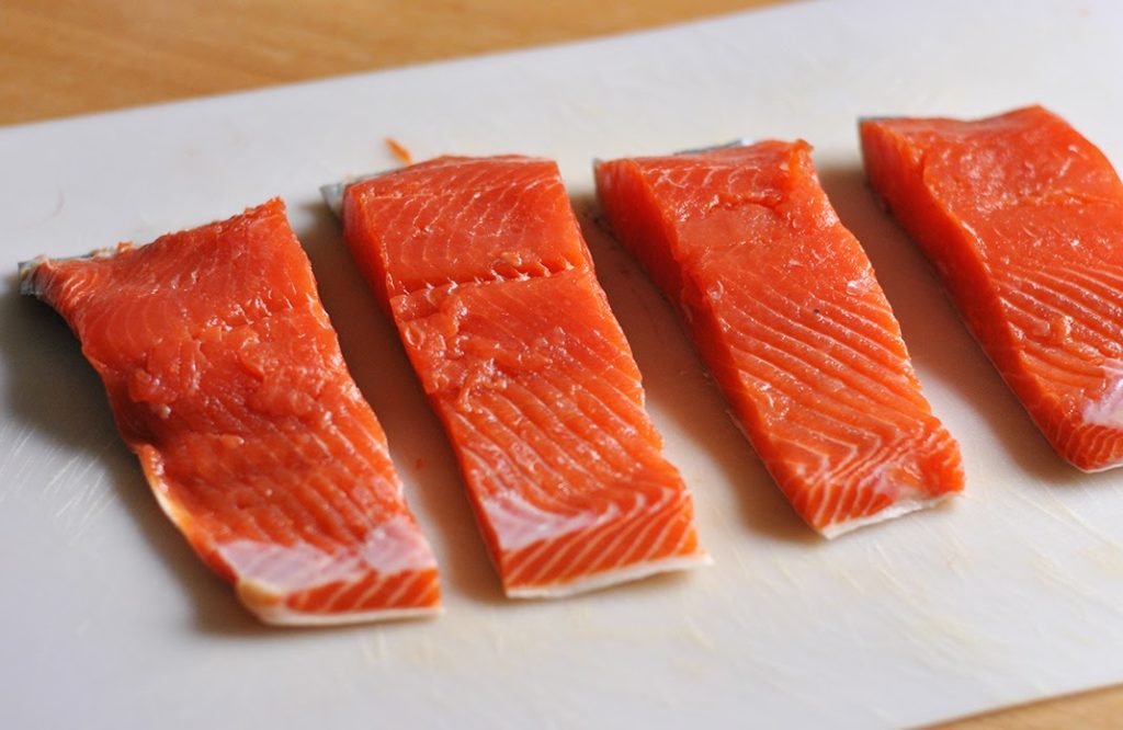 Four raw salmon fillets, ready to cook