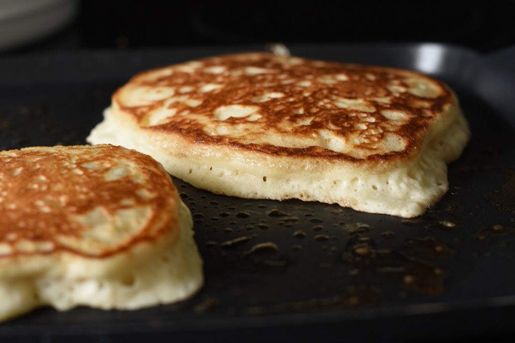 Fluffy Pancakes Cooking on Griddle