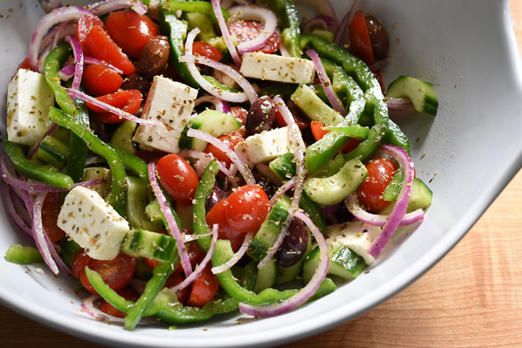 greek salad ingredients in a large bowl