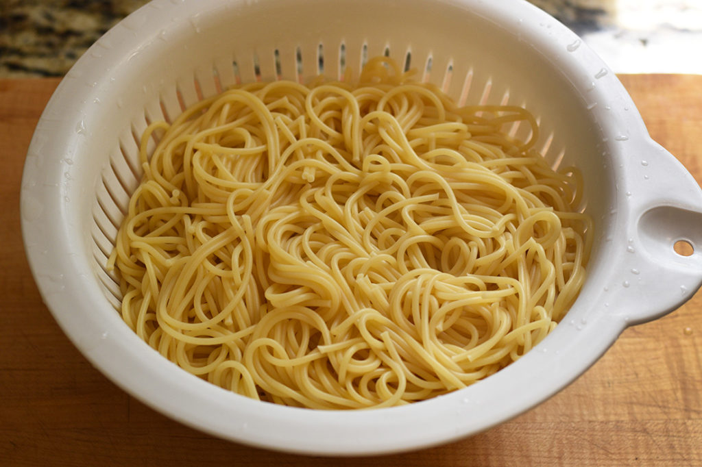Cooked and drained pasta in a sieve